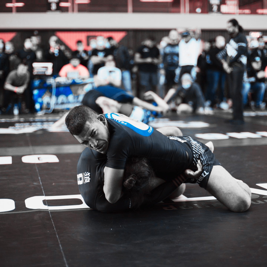 Tobias Thiago Huber BJJ Zwei Kämpfer im Grappling, einer in schwarzer, der andere in blauer Kleidung.
